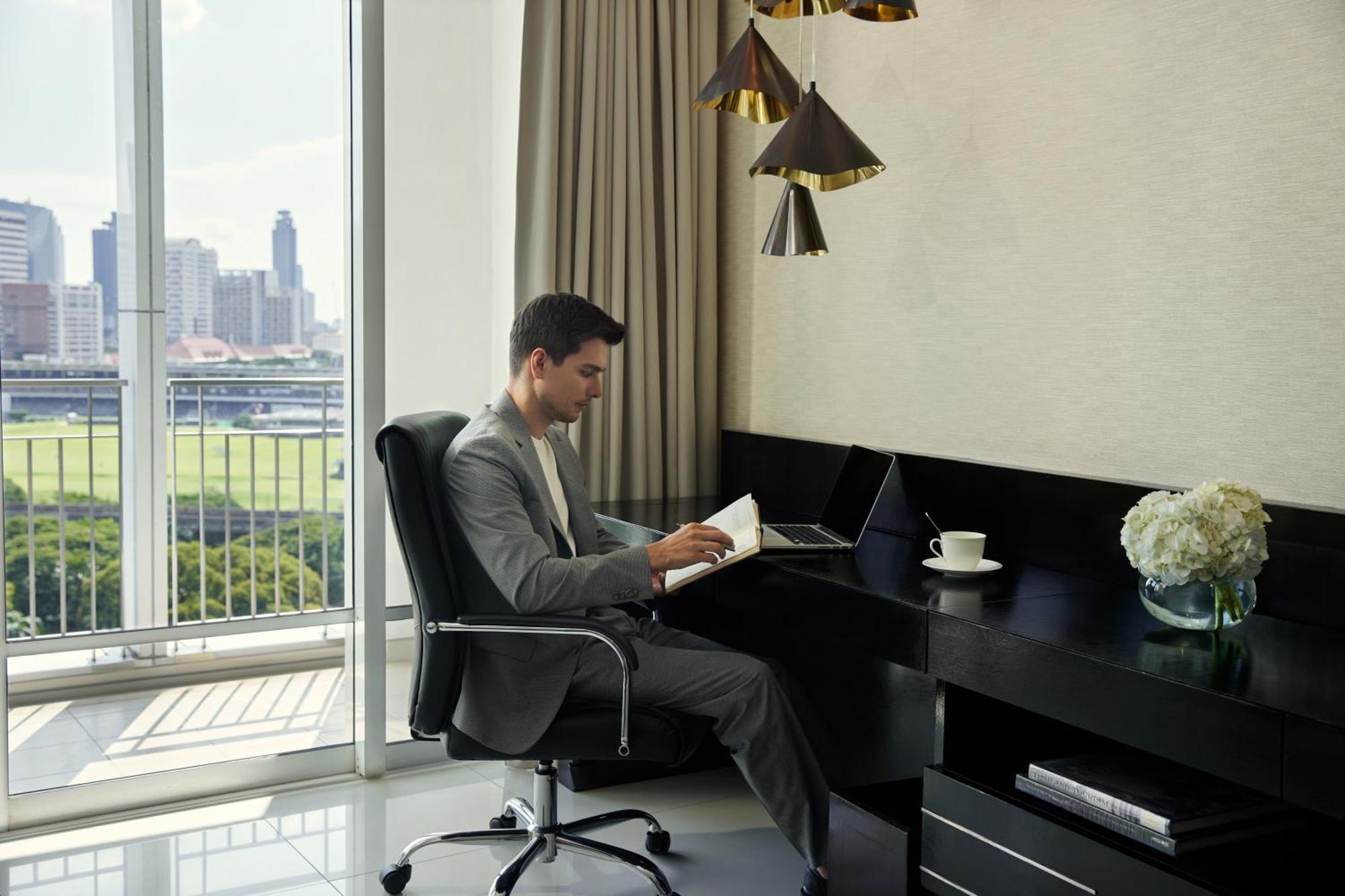 Dusit Suites Hotel Ratchadamri, Бангкок Экстерьер фото A man working at a desk